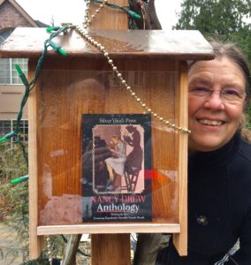 A woman standing next to a book box.